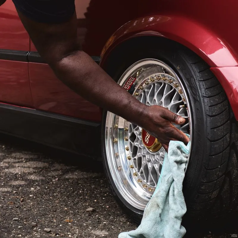 Detailer cleaning a car wheel